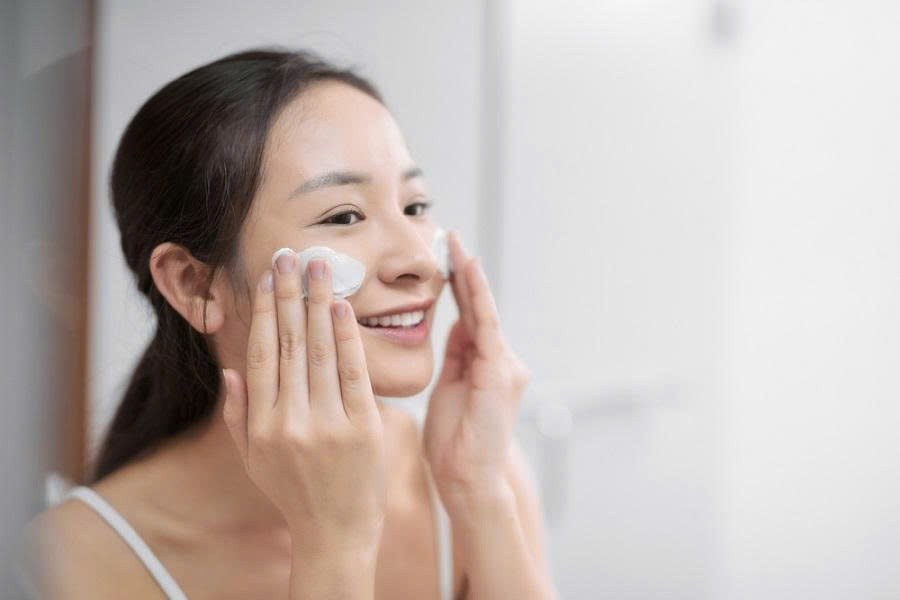 Cô gái đang dùng sữa rửa mặt diếp cá làm sạch da mặt với sản phẩm của Auza Skinlab